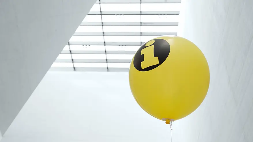 Gelber Ballon mit Informationszeichen